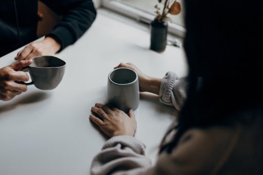 a patient and a counselor drinking coffee during a therapy session