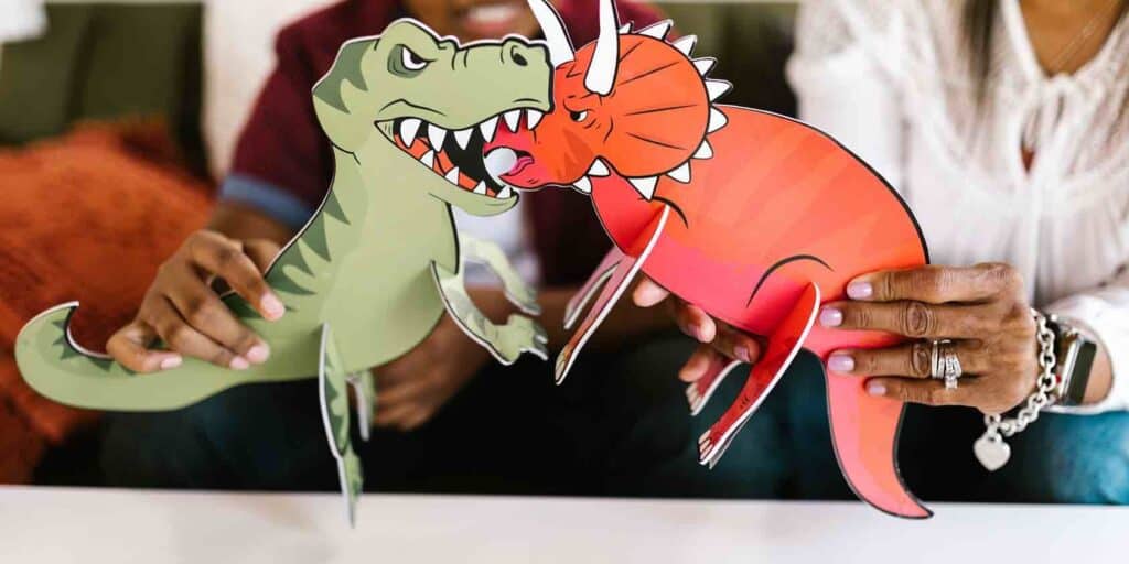 Two paper dinosaurs fighting